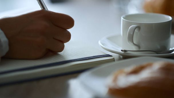 Mujer escritura a mano bloc de notas sentado café trabajo papeleo notas en el restaurante. - Foto, Imagen