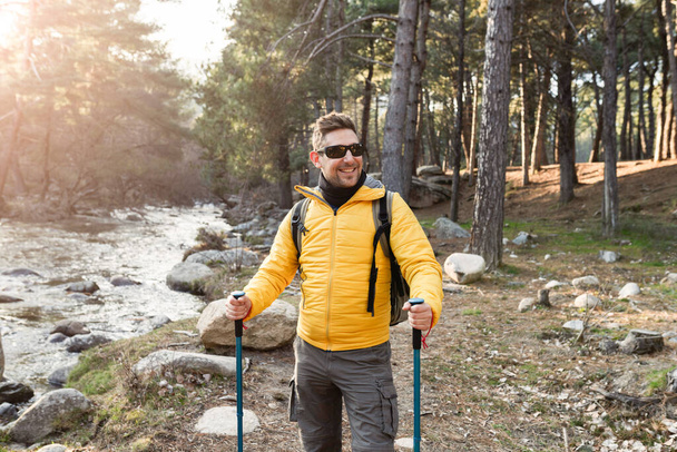 handsome mountaineer man, wearing sunglasses, hiking - Photo, Image