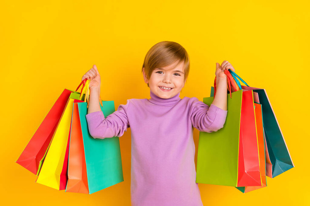 Photo of cute adorable small kid little boy son go shopping to buy mom present for birthday isolated on yellow color background - Fotó, kép