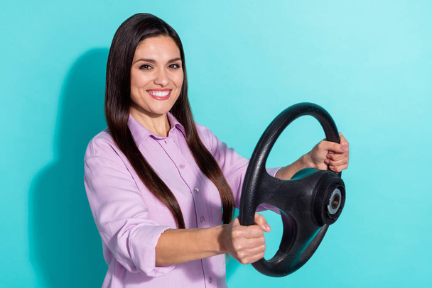 Photo of brunette cool young lady drive car wear purple shirt isolated on teal color background. - Foto, imagen