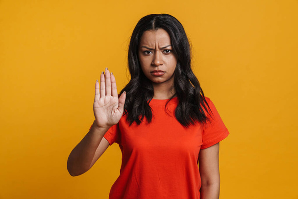 Displeased black woman showing stop gesture at camera isolated over yellow background - Foto, immagini