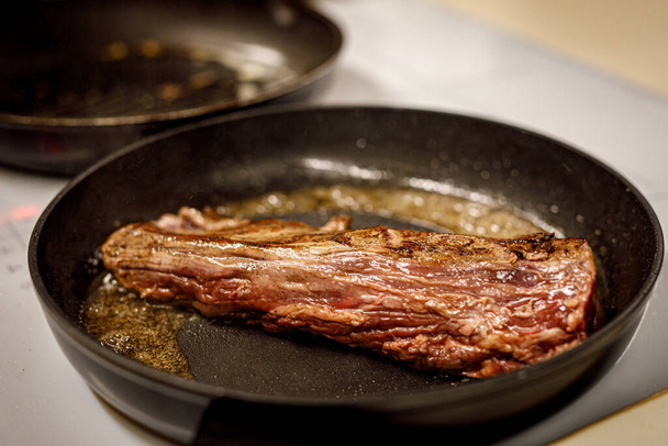 A piece of beef is fried in a pan - Valokuva, kuva