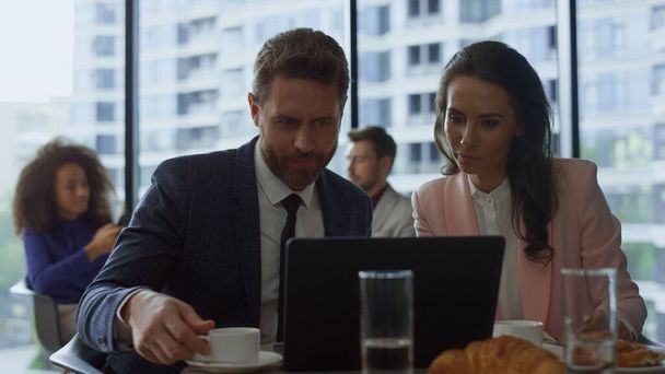 Deux professionnels discutent d'un projet d'entreprise lors d'une réunion en ligne d'ordinateur portable dans un café. - Photo, image