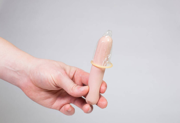 Condom in man's hand, contraception, health safety, safe love - 写真・画像