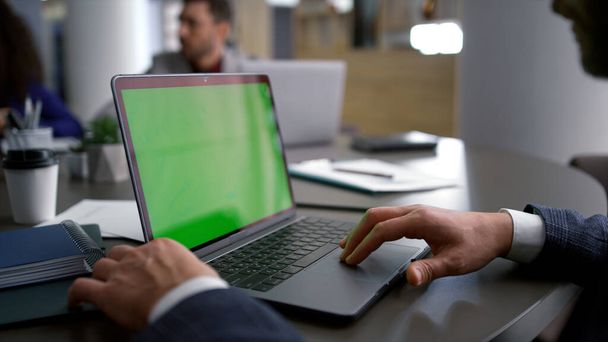 Підприємець шукає зелений екран ноутбука на різноманітній зустрічі ділової команди
. - Фото, зображення