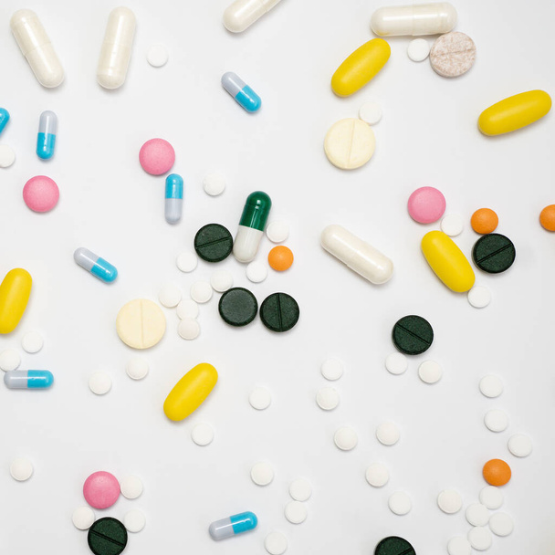 Variedade de drogas em cápsulas e pílulas de cores diferentes em um fundo branco - Foto, Imagem