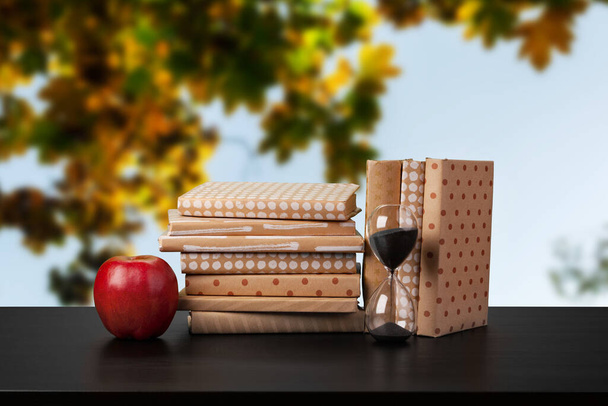 Stack of books on wooden table against blurred background - Φωτογραφία, εικόνα