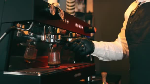 Homme Barista en masque visage fait un cappuccino dans un café-bar. Lockdown Social Restrictions Concept During Covid-19 Pandemic in Restaurants. Femme caissière travaille dans un café en arrière-plan. - Séquence, vidéo