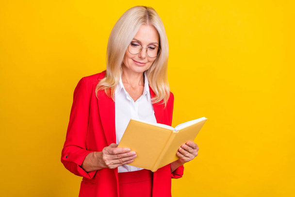 Foto di attraente donna matura leggere libro hobby romanzo apprendimento isolato su sfondo di colore giallo. - Foto, immagini
