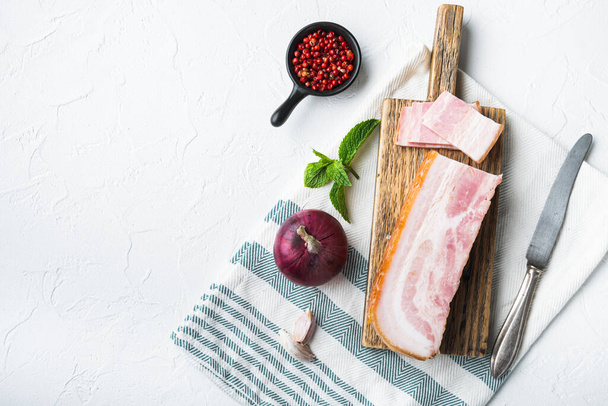 Smoked bacon, whole slab  with herbs on white background, top view with space for text. - Photo, Image