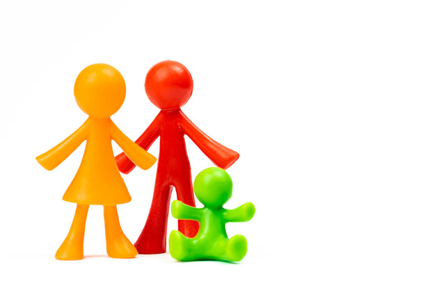 Figurine di giovane famiglia con primo figlio su sfondo bianco isolato. Concetto di padre e madre adulti. Copia spazio - Foto, immagini