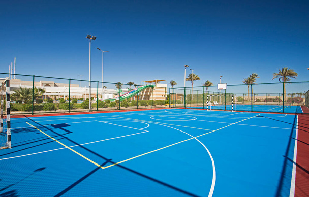 terrain de sport polyvalent en argile extérieure avec surface bleue et filets à l'hôtel tropical station de vacances - Photo, image