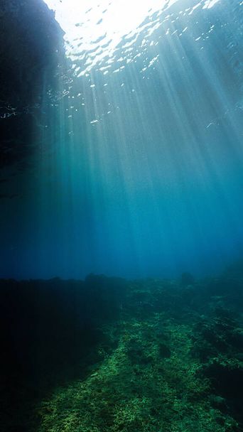 Underwater scene in the blue sea with beautiful rays of sunlight - Photo, Image