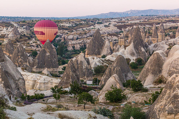 GOREME, TURKEY - JULY 21, 2019: Hot air balloon above Cappadocia landscape, Turkey - 写真・画像