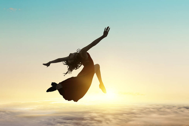 Female dancer against sunset sky . Mixed media - Foto, immagini