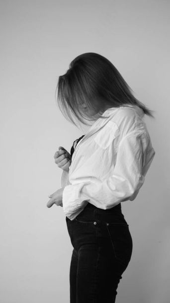 Černá a bílá fotografie mladé krásné ženy s dlouhými vlasy na sobě v košili pózuje ve studiu.   - Fotografie, Obrázek