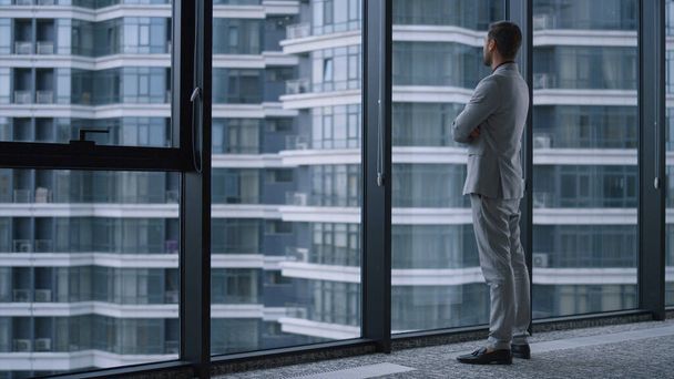 Úspěšný muž držící ruce při pohledu do okna v business office building centre. - Fotografie, Obrázek