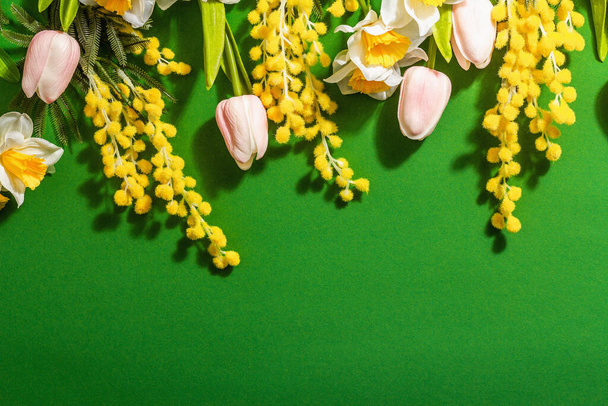 Festive floral background with traditional spring flowers on a green background. Mothers and Women Day, Easter concept, flat lay, copy space, top view - Foto, Imagem