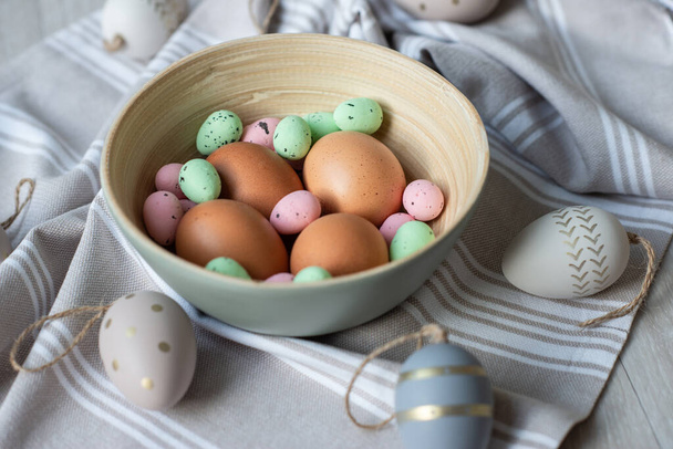 Striped and dotted easter decorative and natural eggs on bright pastel texture - Foto, afbeelding