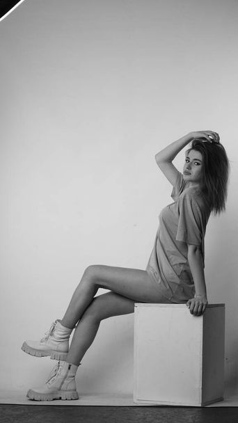 Black and white photo of young beautiful woman with long hair wearing in t-shirt in studio.   - Foto, Bild