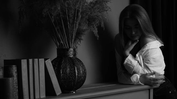 Stüdyoda piyanonun yanında uzun saçlı, beyaz gömlekli, güzel, şehvetli ve seksi bir kadının siyah beyaz fotoğrafı..   - Fotoğraf, Görsel