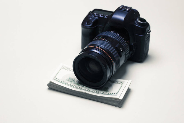 Profesyonel bir fotoğraf makinesinin yanında yığınla para. Kazanç kavramı, fotoğrafçının gelişimi, paparazzilerin çalışması, pahalı fotoğraf ekipmanları. Boşluğu kopyala. - Fotoğraf, Görsel