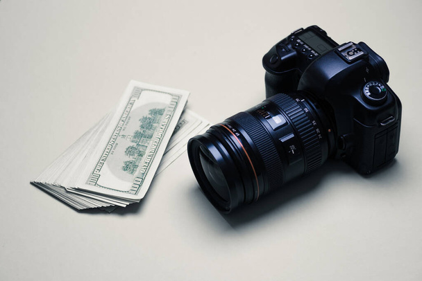 Profesyonel bir fotoğraf makinesinin yanında yığınla para. Kazanç kavramı, fotoğrafçının gelişimi, paparazzilerin çalışması, pahalı fotoğraf ekipmanları. Boşluğu kopyala. - Fotoğraf, Görsel