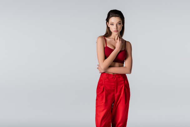 young model in red outfit posing isolated on grey - Fotografie, Obrázek