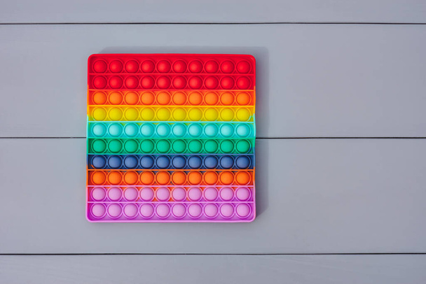 Bright colorful silicone toy Close-up, Pop It. Popular anti-stress toy. On a gray background - Zdjęcie, obraz
