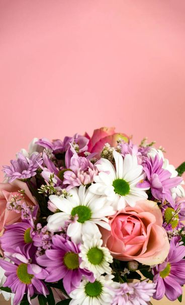 Hermoso ramo de flores sobre un fondo rosa. Rosas, crisantemos blancos y rosados. Lugar para el texto - Foto, Imagen