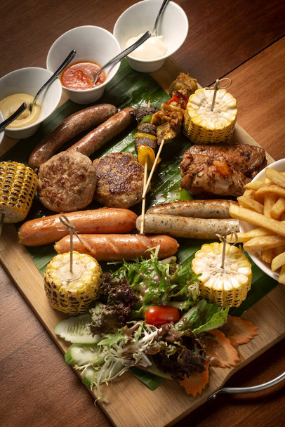 BBQ prato de carne mista com almôndegas, salsichas, espetos e asas de frango no fundo de madeira - Foto, Imagem