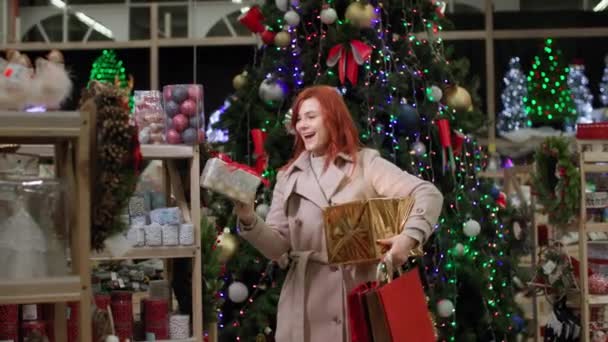 Újévi vásárlás, boldog női vásárló választja ajándékok és lakberendezési a szupermarketben kedvezmények, mosolyog, és néz a kamerába - Felvétel, videó