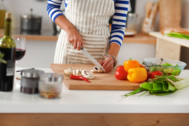 Young woman cutting vegetables in kitchen - Φωτογραφία, εικόνα