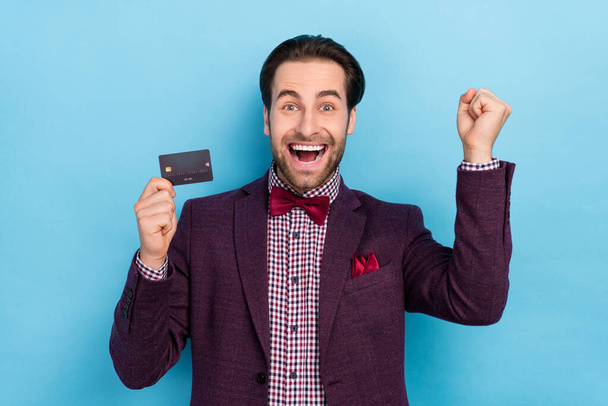 Portrait of overjoyed formalwear guy raise fists in victory triumph success hold plastic card isolated on blue color background - Fotografie, Obrázek