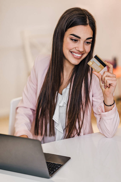 Iloinen iloinen hymyilevä nuori aikuinen nainen tekee verkko-ostoksia, e-ostoksia tyytyväinen yrittäjä tekee online-maksu maksaa palvelun tai tavaroiden itsenäinen freelancer kerätä maksu luottokortti - Valokuva, kuva