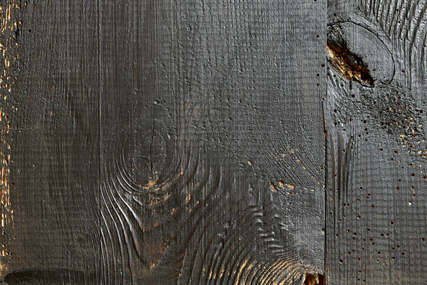 tablones viejos dañados por gusanos, mostrados de cerca, puertas pintadas de negro, tablones unidos - Foto, Imagen
