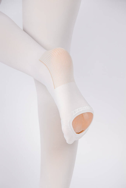 Anti-embolic Compression Hosiery for surgery isolated on white. Medical white stockings, tights for varicose veins and venouse therapy. Thrombo embolic deterrent hose or anti-embolism stockings - Фото, изображение