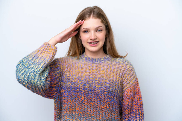tiener russisch meisje geïsoleerd op witte achtergrond salueren met de hand met gelukkig expressie - Foto, afbeelding