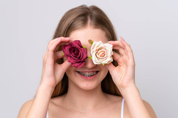 Teenager Russian girl isolated on white background holding flowers with happy expression. Close up portrait - Foto, Imagem