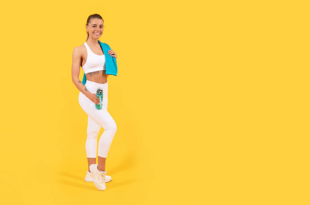 sportvrouw met waterfles op gele achtergrond. kopieerruimte - Foto, afbeelding
