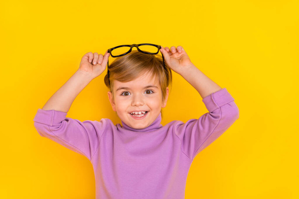 Photo of cheerful impressed little boy see huge bargains on black friday advertisement isolated on yellow color background - Foto, Bild