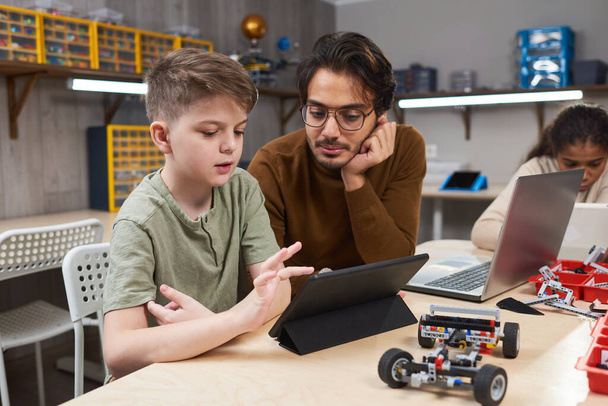Boy controlling the robot from a tablet pc - Photo, Image