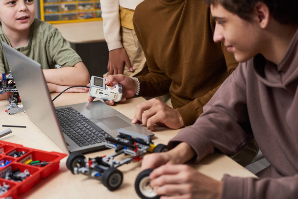 Подростки, использующие ноутбук на уроке робототехники - Фото, изображение