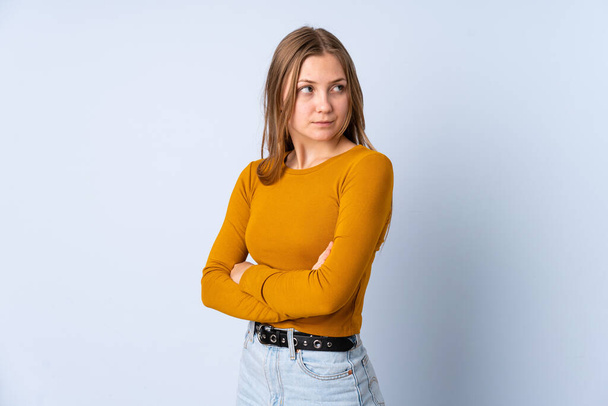 Teenager Ukrainian girl isolated on blue background keeping the arms crossed - Photo, Image
