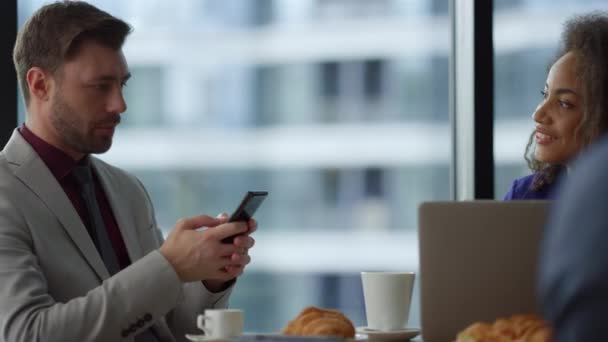 Мультиэтнические пары деловых людей, сидящих с помощью телефона ноутбука в кафе офис. - Кадры, видео
