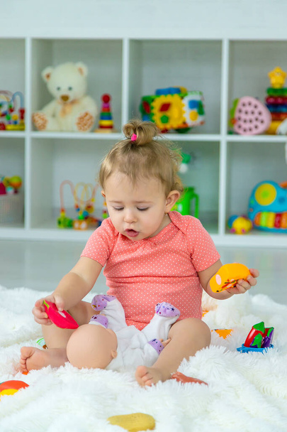 Baby speelt met speelgoed in haar kamer. Selectieve focus. Kind. - Foto, afbeelding