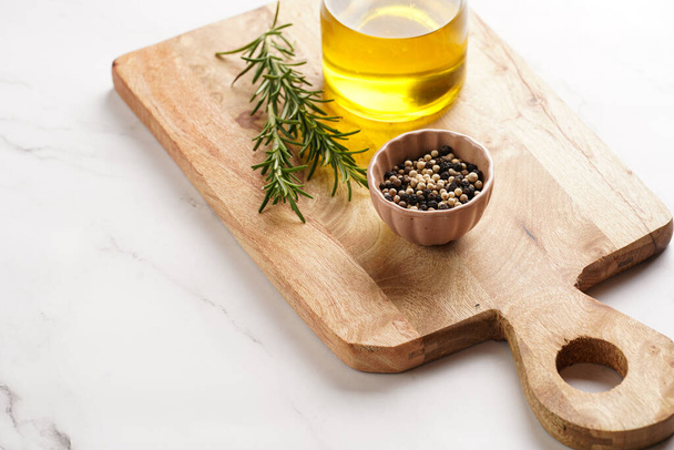 Ingredientes de cocina: aceite de oliva, romero fresco, leche, pimienta sobre tabla de madera - Foto, imagen