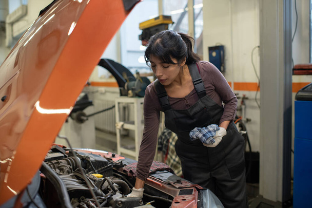 Молодая работница автосервиса по ремонту автомобилей - Фото, изображение