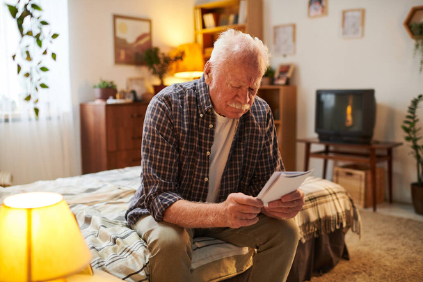 Współczesny starszy człowiek przeglądający zdjęcia swoich krewnych - Zdjęcie, obraz
