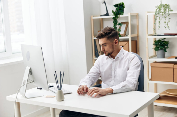 オフィスワークテクノロジーの白いシャツを着たハンサムなビジネスマン - 写真・画像